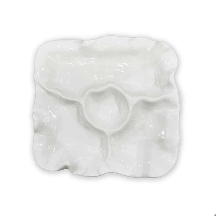 White ceramic oyster-shaped dish on a white background
